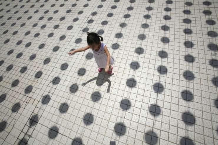 kislány játszik a kínai holdújév ünepek lampionjai alatt.